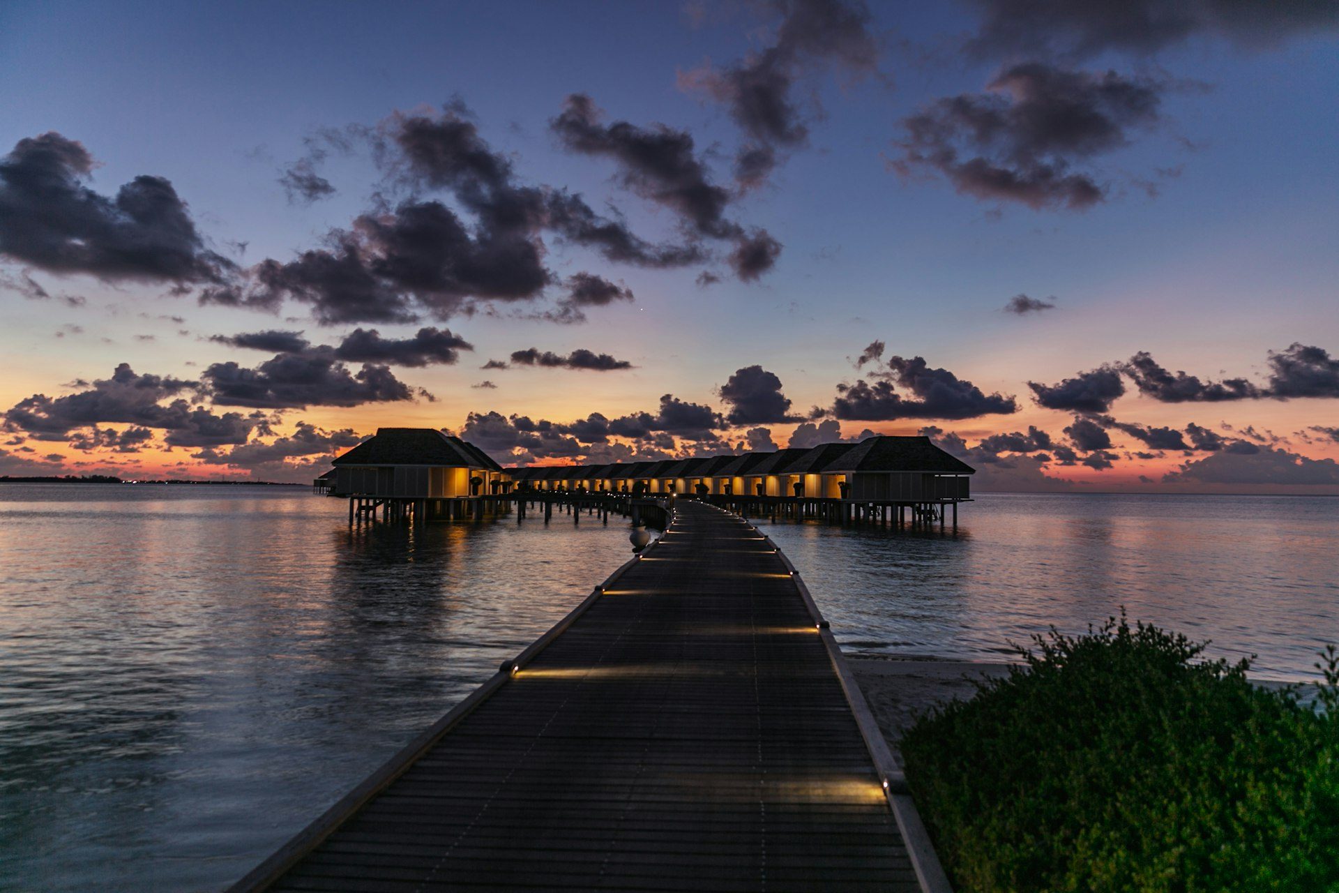 An overwater villa walkway at dusk