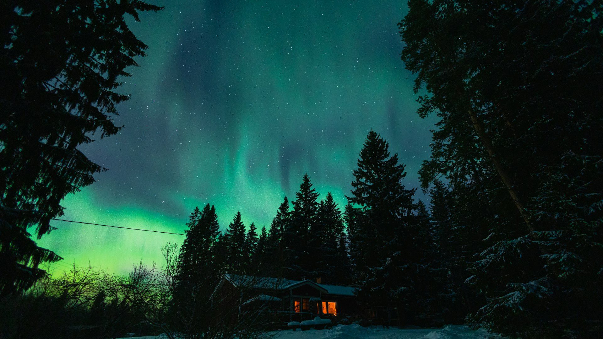 The northern lights over snowbound cabins
